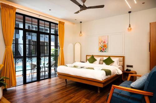 a bedroom with a bed and a large window at Barefoot bliss by iLiF Hotels in Revadanda