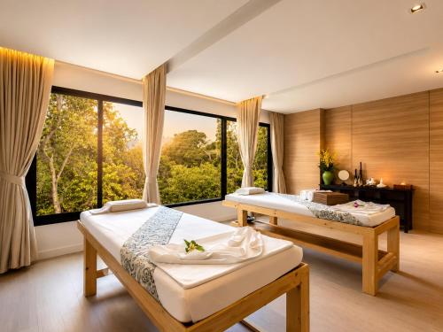 a bedroom with two beds and a large window at Relax, Swim & Stay Active in this Duplex - UTL B131 in Rawai Beach