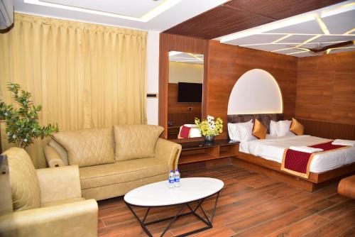 a hotel room with a bed and a couch and a table at HOTEL THIRD EYE bY RAMANA TOWERS in Tiruvannāmalai