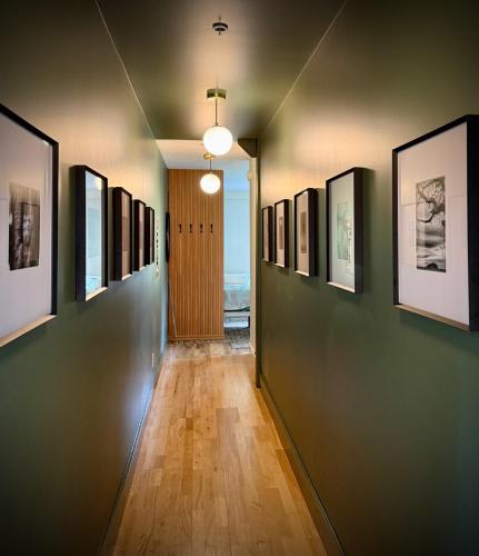 a hallway with a row of pictures on the walls at Artisan Suites on Bowen in Bowen Island