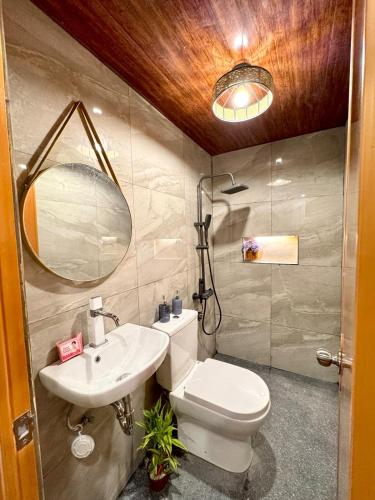 a bathroom with a toilet and a sink and a mirror at Casa de Villanueva in Davao City