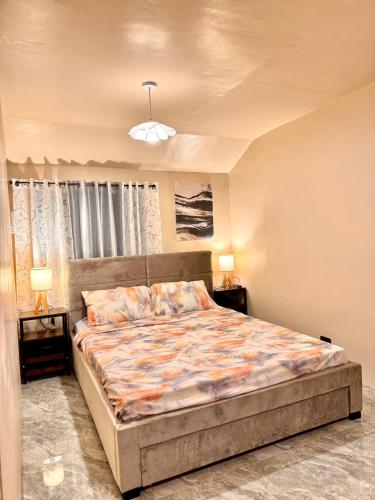 a bedroom with a large bed with two night stands at Casa de Villanueva in Davao City