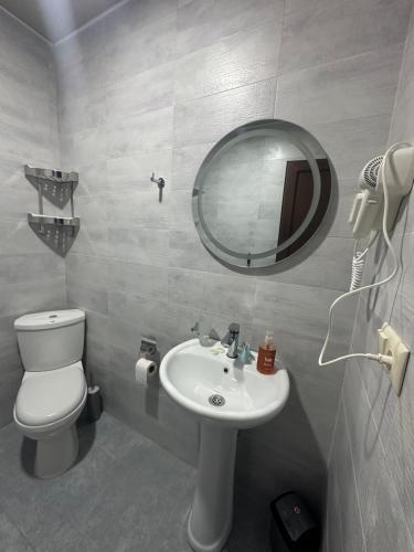 a bathroom with a sink and a toilet and a mirror at Luso in Batumi