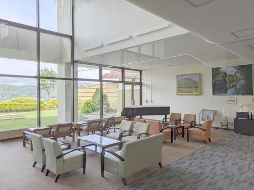 a waiting room with a piano and chairs at Nunohiki Onsen Komoro in Komoro