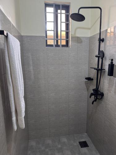 a shower with a glass door in a bathroom at Aiden House Arusha in Arusha