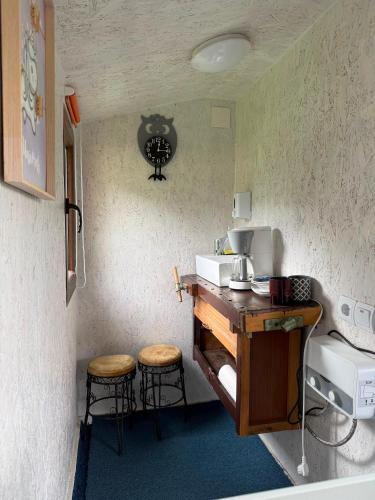a kitchen with a counter with a sink and stools at Britania Hobbit in Predeluţ