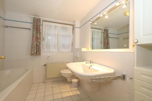 a bathroom with a sink and a toilet and a mirror at Appartement-Morgenroth in Munkmarsch