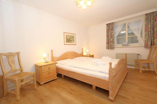 a bedroom with a large bed and a chair at Appartement-Morgenroth in Munkmarsch