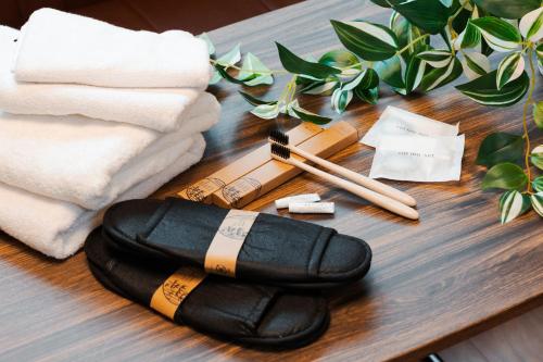 a wooden table with towels and a wand and chopsticks at Osaka Petite Tanuki Inn Neyagawa in Neyagawa