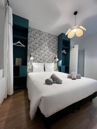 a bedroom with a large white bed with a wall at Le 101 - Les Locations ISAHORA in Eu