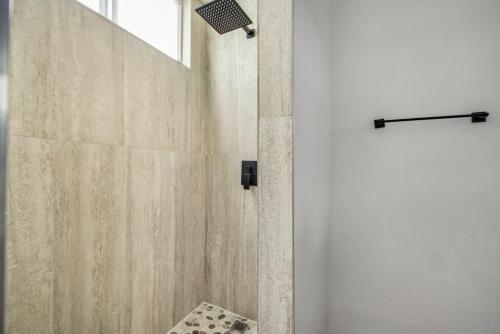 a bathroom with a shower with a glass door at Beachfront Condo on A LowKey Beach in Sunset Beach