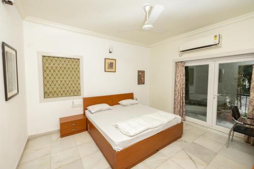 a bedroom with a bed and a large window at Ishan Apartments 3BHK in Vadodara
