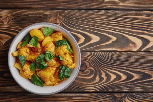 a bowl of food on a wooden table at Super Townhouse Oak Madhapur Nera Regency in Hyderabad