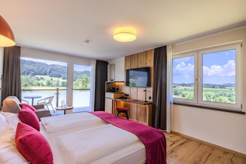 a hotel room with a bed and a large window at Hotel Haberl - Attersee in Attersee am Attersee