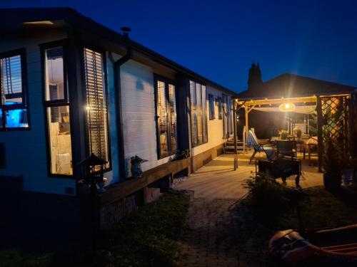 a house with a patio at night at JOY Boutique Chalet Berkhout - Hoorn in De Hulk