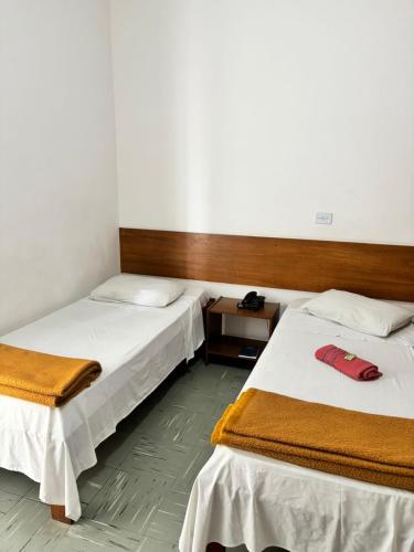 a room with two beds and a phone in it at Six's Hotel in Jacareí