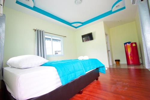 a bedroom with a bed with a blue ceiling at Bannrommai Sattahip in Sattahip
