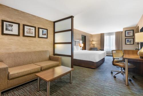 a hotel room with a couch and a bed at Comfort Inn & Suites Airport North in Calgary