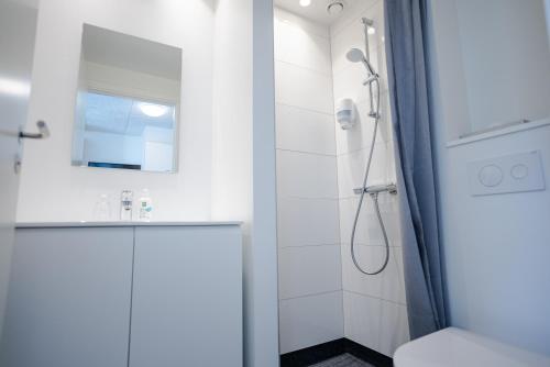 a white bathroom with a shower and a sink at Severin Kursuscenter og Konferencehotel in Middelfart