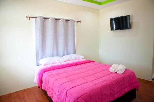 a bedroom with a pink bed with a pink blanket at Bannrommai Sattahip in Sattahip