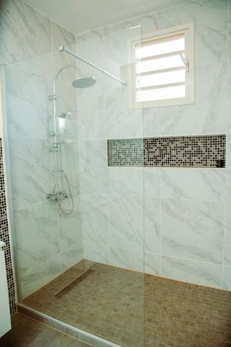 a bathroom with a shower with a glass door at Villa Domi in Antsiranana