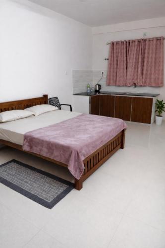 a bedroom with a large bed and a sink at Harichandhanam stay in Guruvāyūr