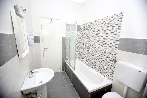 ein weißes Bad mit einem Waschbecken und einem WC in der Unterkunft B&B Salernoway in Salerno