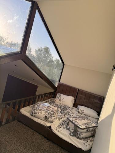 a bed in a room with a large window at منتجع النادر الريفي in Az Zulfi
