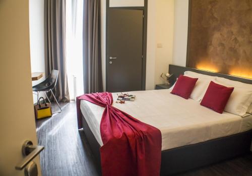 a bedroom with a large bed with red pillows at Acapulco Hotel in Cattolica