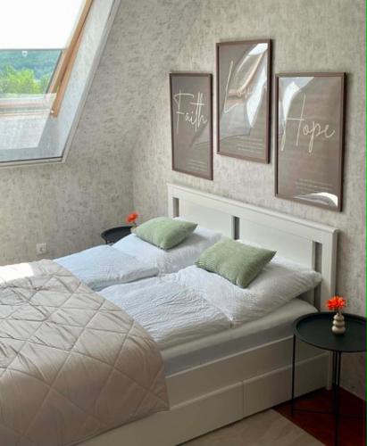 a bedroom with two beds and pictures on the wall at Astrum Apartman in Egerszalók