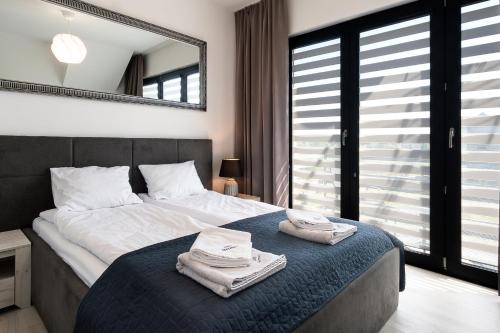 a bedroom with a large bed with towels on it at AWO Apartamenty in Łeba