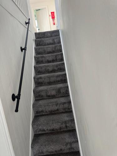 a stairway leading up to a room with a white wall at 31a locking road in Weston-super-Mare