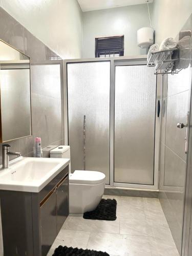 a bathroom with a toilet and a sink and a shower at Abban homes in Kampala