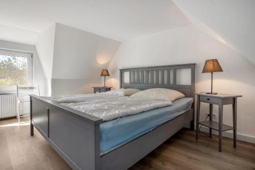 a bedroom with a large bed and two tables at Ankerhaus 1 in Trent