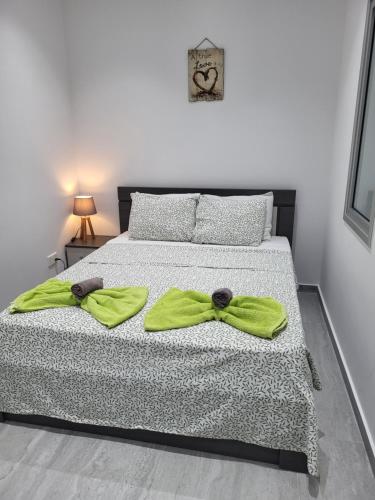 a bedroom with a bed with a green bow tie on it at Chryso Apts Protaras in Protaras