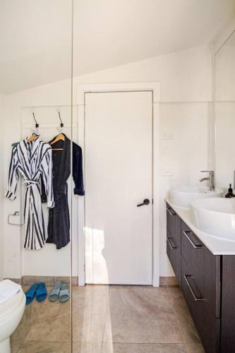 a bathroom with a sink and a toilet and a glass door at Chiara's Wellness Studio Sauna and Outdoor Bath in Sorrento