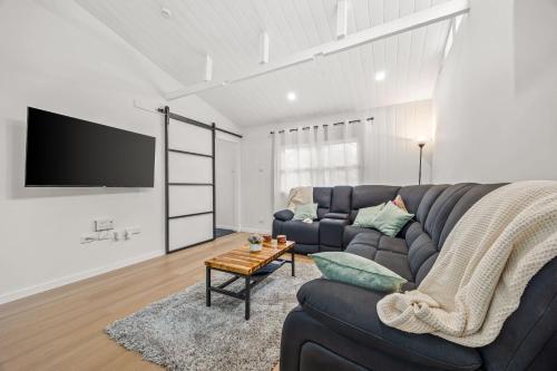 a living room with a couch and a tv at What-A-View Cottage Halls Gap in Halls Gap