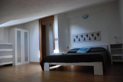 a bedroom with a bed in a white room at Casetta D'Este in Palmadula