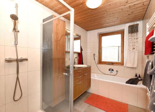 ein Badezimmer mit Dusche, Badewanne und Waschbecken in der Unterkunft Hausblick in Au im Bregenzerwald