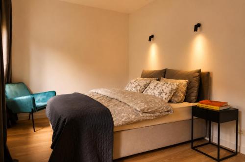 a bedroom with a bed and a blue chair at Vinyl & Wine Retreat by THE HOUSE Experience Collection in Škaljari