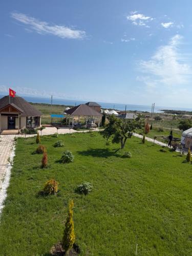 a green yard with trees in the grass at Guest House Archa in Tong