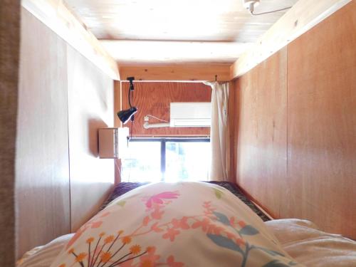 a bed in a small room with a window at EkimaehouseSamaru in Shimanto-cho