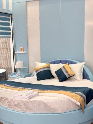 a bedroom with a large bed with a blue headboard at Golden Lotus Hotel in Buôn Hồ