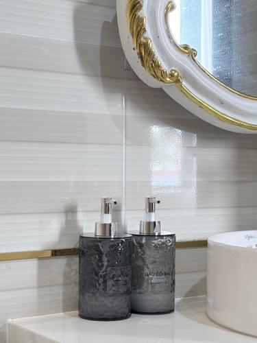 a bathroom with two soap dispensers in front of a mirror at Golden Lotus Hotel in Buôn Hồ