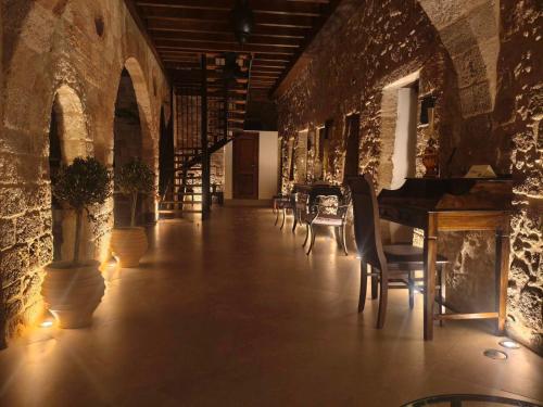 a room with a piano and chairs in a building at Jivaeri Luxury Suites in Rhodes Town