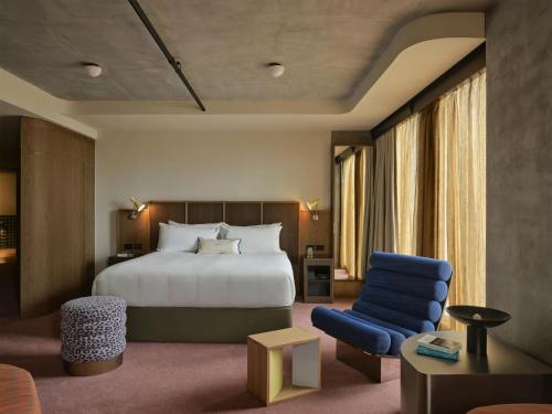 a hotel room with a bed and a blue chair at Hannah St Hotel Melbourne in Melbourne
