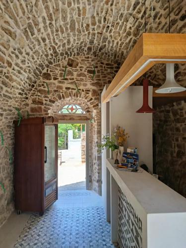 a kitchen with a stone wall and a doorway at Yermata Kalamoti in Kalamoti