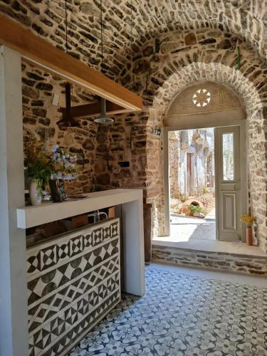 a kitchen with a stone wall and a door at Yermata Kalamoti in Kalamoti