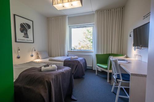 a hotel room with two beds and a desk at Severin Kursuscenter og Konferencehotel in Middelfart