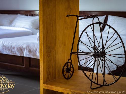 a large wheel is on the floor next to a bed at Sandy Clay Bungalows in Sihanoukville